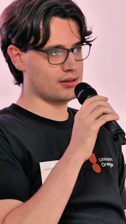 A speaker holding a microphone at a business event, from Business Showreel